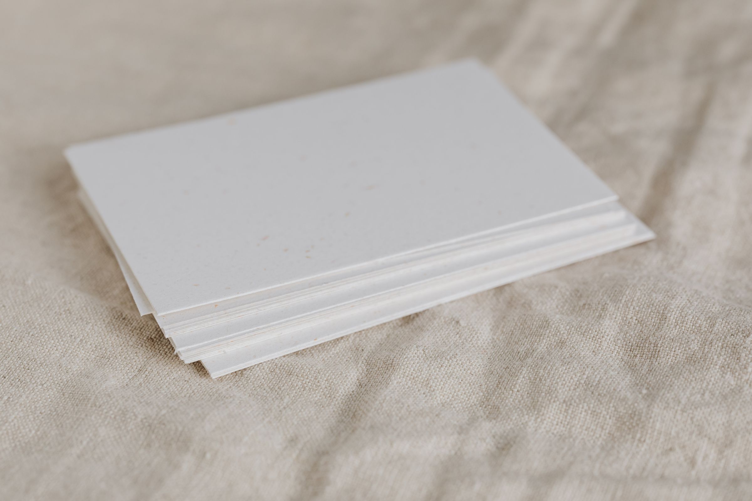 A stack of blank cards on linen.